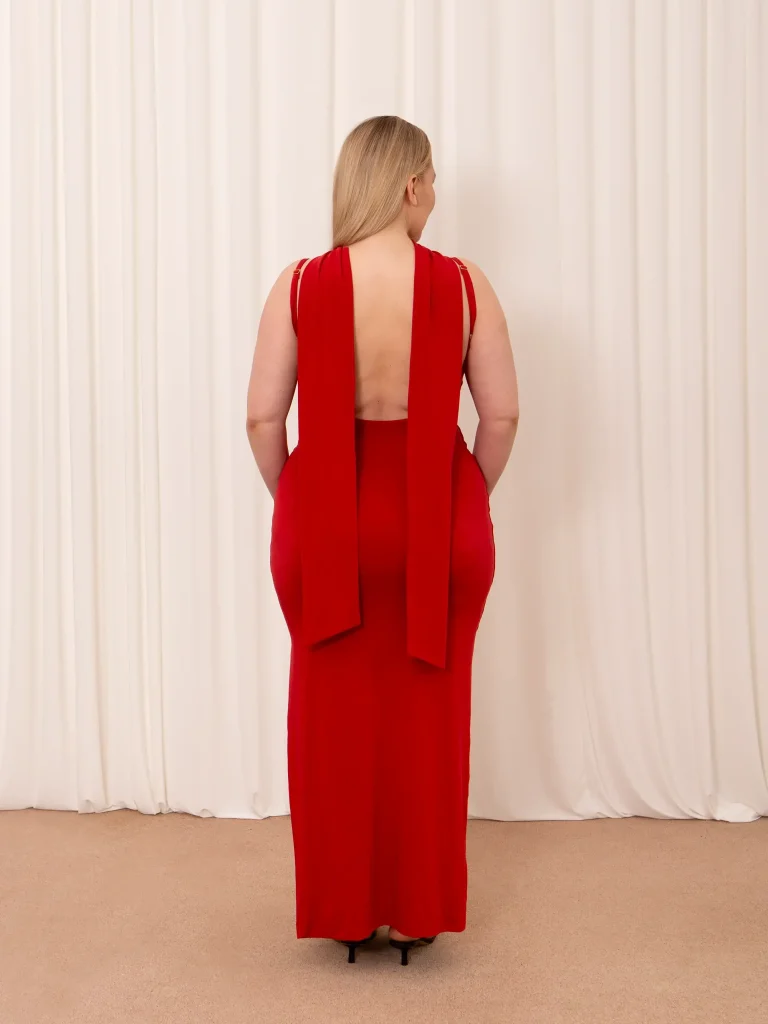 A model showing the back of the more popular AYM dresses. It is a red dress with a bare back.